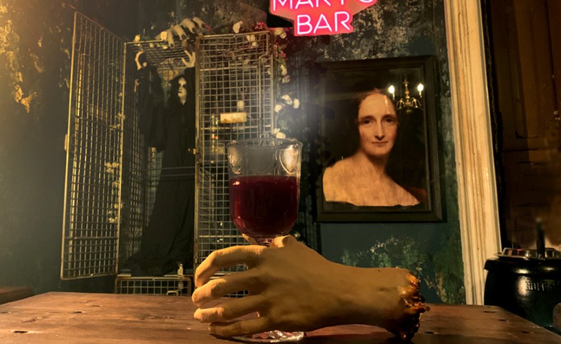 Fake hand holding a glass of mulled wine in Bloody Mary's Bar